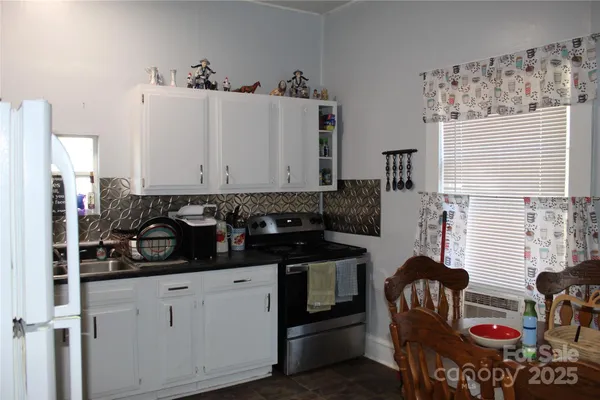 a kitchen with stainless steel appliances a stove a sink and white cabinets
