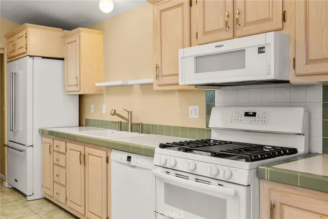 a kitchen with granite countertop white cabinets and white appliances