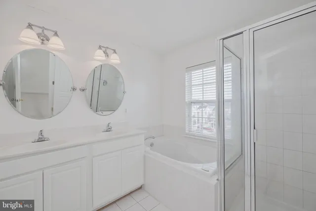a bathroom with a double vanity sink mirror and bathtub