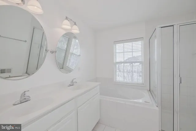 a bathroom with a tub a sink and mirror