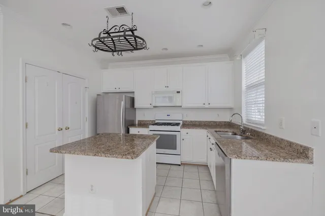 a kitchen with a sink a stove and cabinets