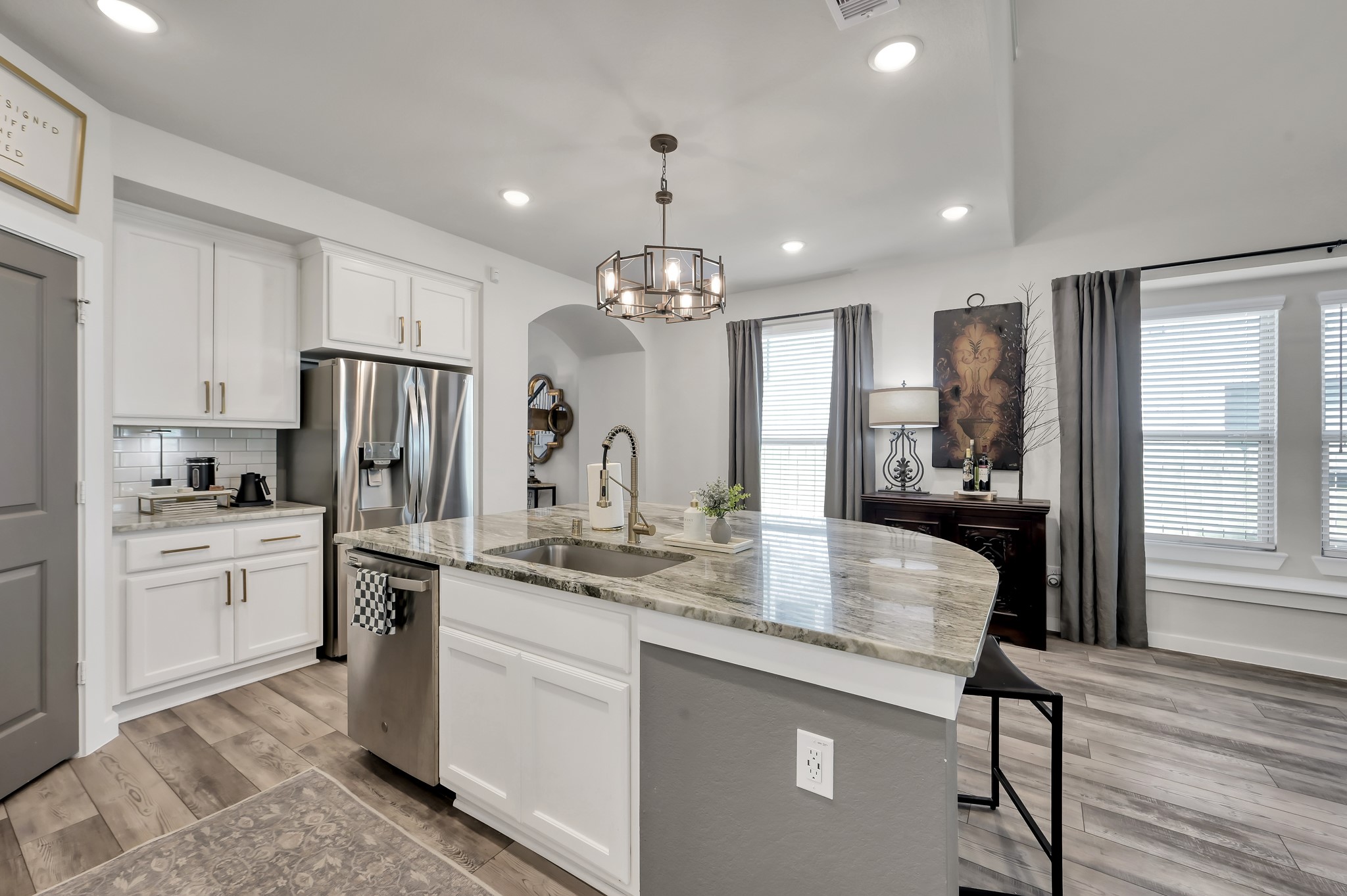 554 Timber Voyage Court Conroe, TX 77304 - Photo 8 of 35 a kitchen with stainless steel appliances granite countertop a refrigerator a sink dishwasher a stove and white cabinets with wooden floor