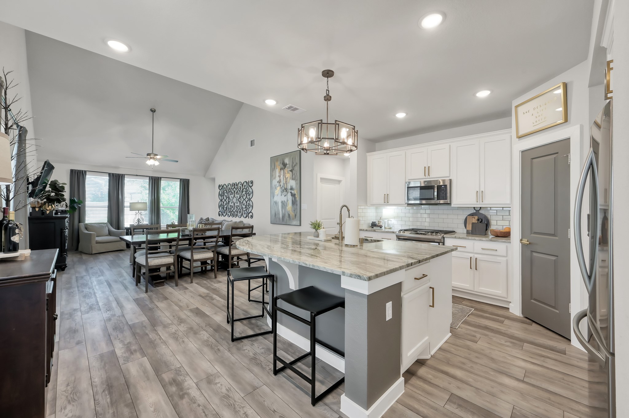 554 Timber Voyage Court Conroe, TX 77304 - Photo 9 of 35 a large kitchen with kitchen island a sink a stove a dining table and chairs