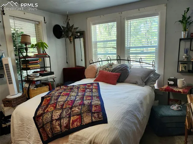 a bedroom with bed and a large window