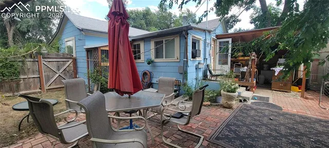 a view of a patio with table and chairs potted plants and large tree