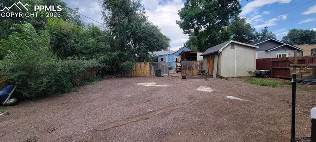 a view of a house with a yard and large tree