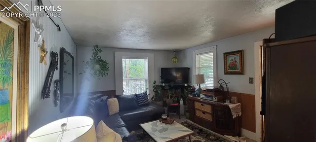 a living room with furniture a flat screen tv and a window