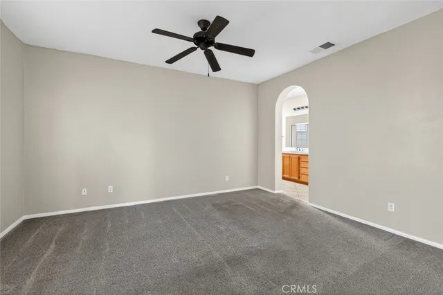 an empty room with a ceiling fan and window
