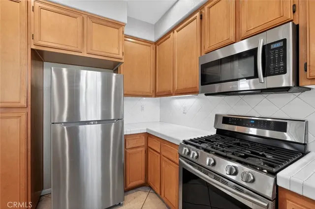 a kitchen with stainless steel appliances granite countertop a stove microwave and refrigerator