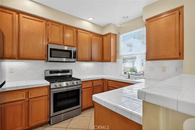 a kitchen with stainless steel appliances granite countertop a sink stove and microwave