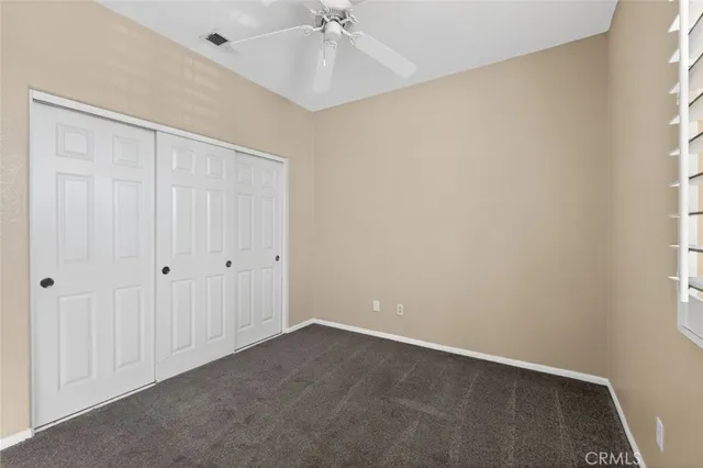 an empty room with a ceiling fan and a window