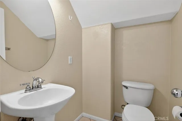 a bathroom with a toilet a sink and mirror