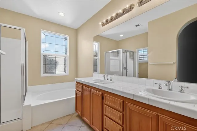 a bathroom with a granite countertop sink mirror and a bathtub