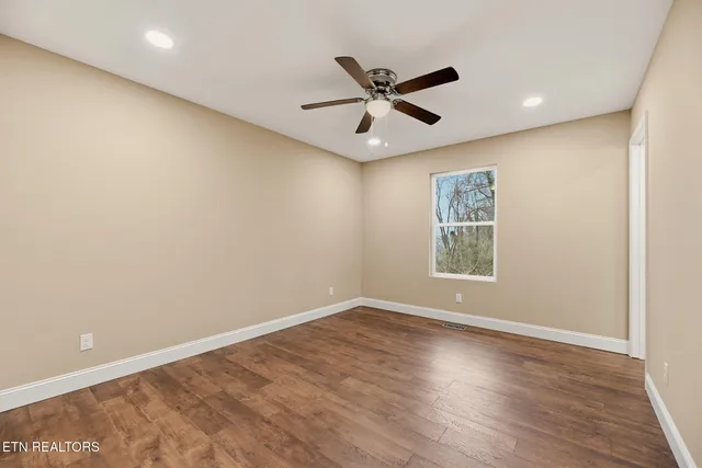 a view of a big room with wooden floor and windows