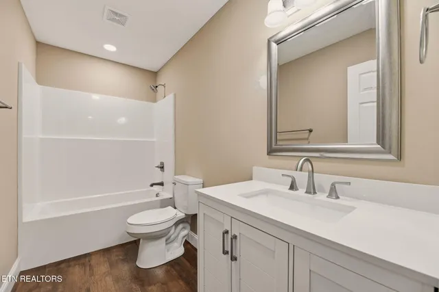 a bathroom with a sink a toilet and a large mirror