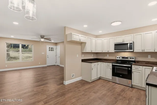 a kitchen with stainless steel appliances granite countertop a stove a sink and a refrigerator