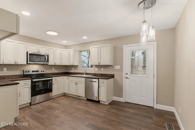 a kitchen with stainless steel appliances granite countertop a stove a sink and a refrigerator
