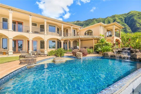 a front view of a house with swimming pool having outdoor seating