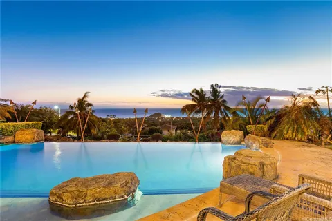 a view of a swimming pool with a patio and dining space
