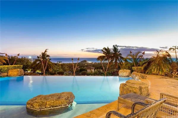 a view of a swimming pool with a patio and dining space