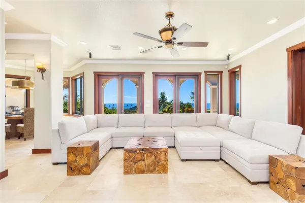 a living room with furniture ceiling fan and a large window