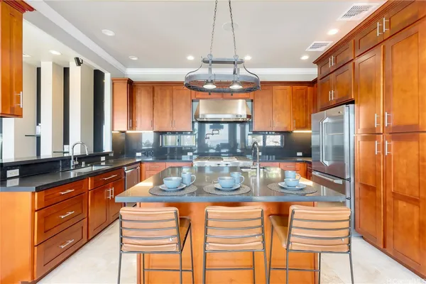 a kitchen with stainless steel appliances granite countertop a refrigerator a stove and a sink