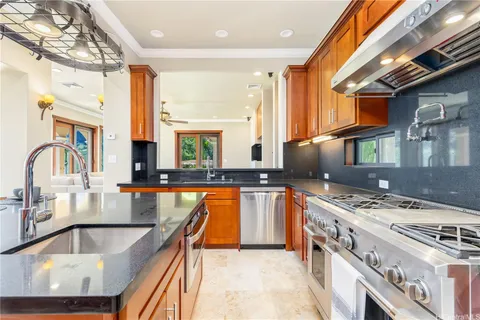 a kitchen with stainless steel appliances granite countertop a sink stove and cabinets