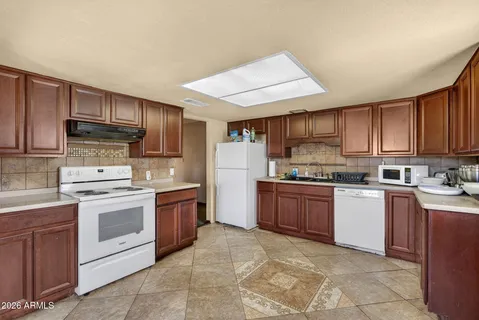 a kitchen with stainless steel appliances granite countertop a refrigerator stove and a sink
