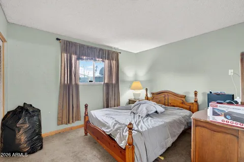 a bed sitting in a bedroom next to a window and a potted plant