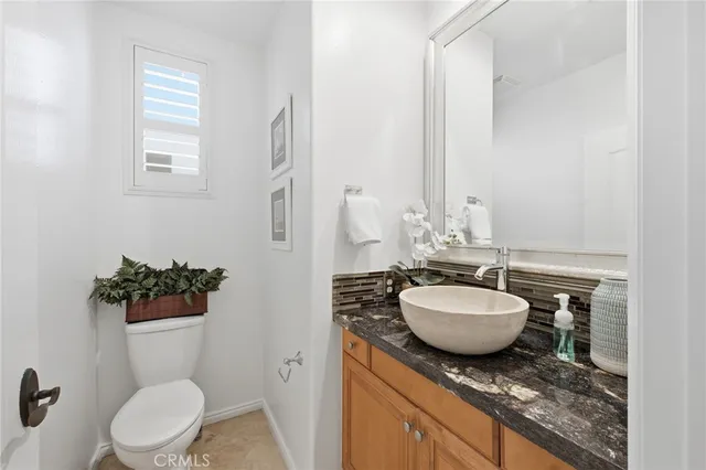 a bathroom with a granite countertop toilet sink and mirror