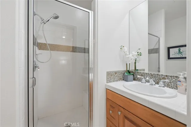 a bathroom with a granite countertop shower sink and mirror