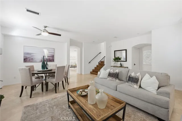 a living room with furniture a rug and white walls