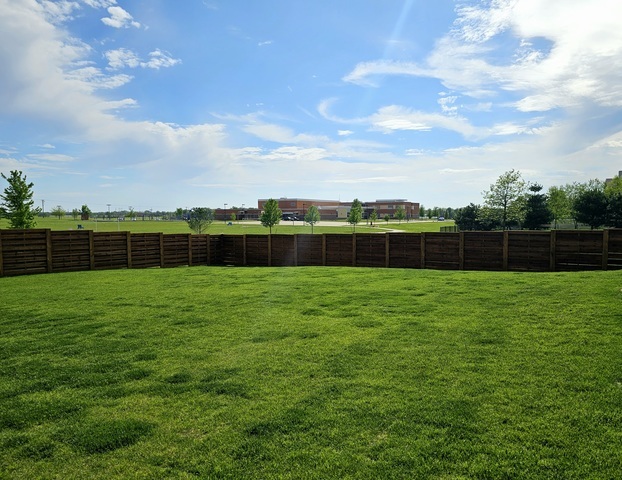 a view of yard with grass & fence