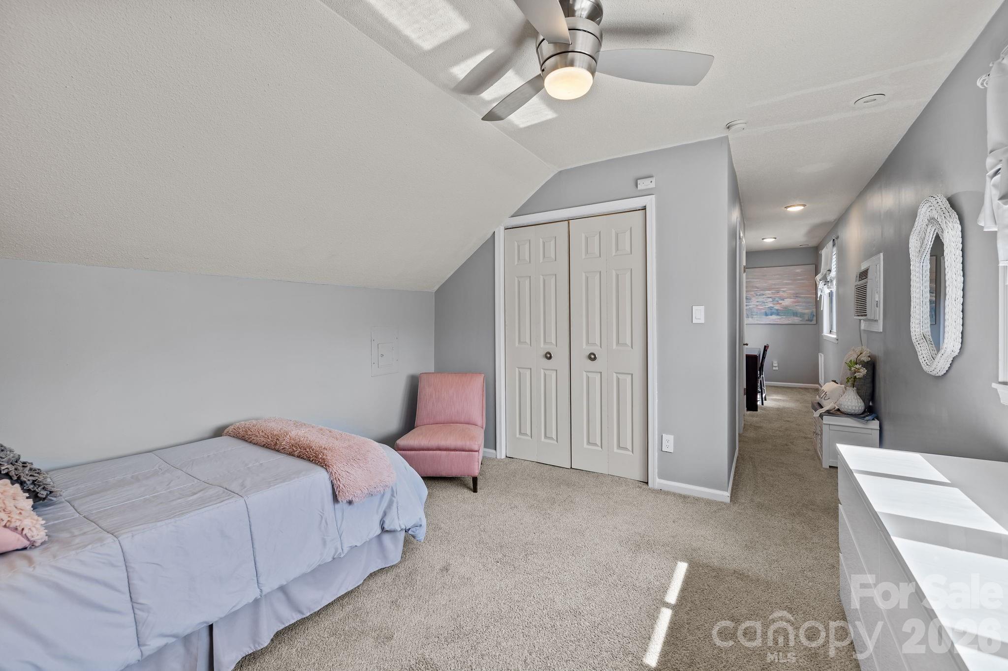 9067 Tulagi Court Fort Mill, SC 29708 - Photo 23 of 44 a spacious bedroom with a bed and a chandelier