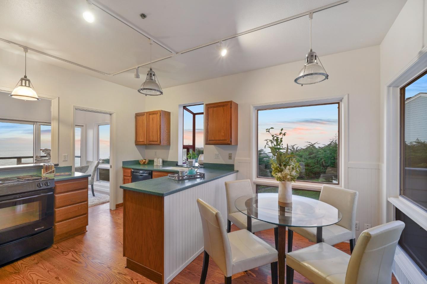 215 Roberts Road Pacifica, CA 94044 - Photo 35 of 40 a kitchen with a stove a sink dishwasher a dining table and chairs with wooden floor