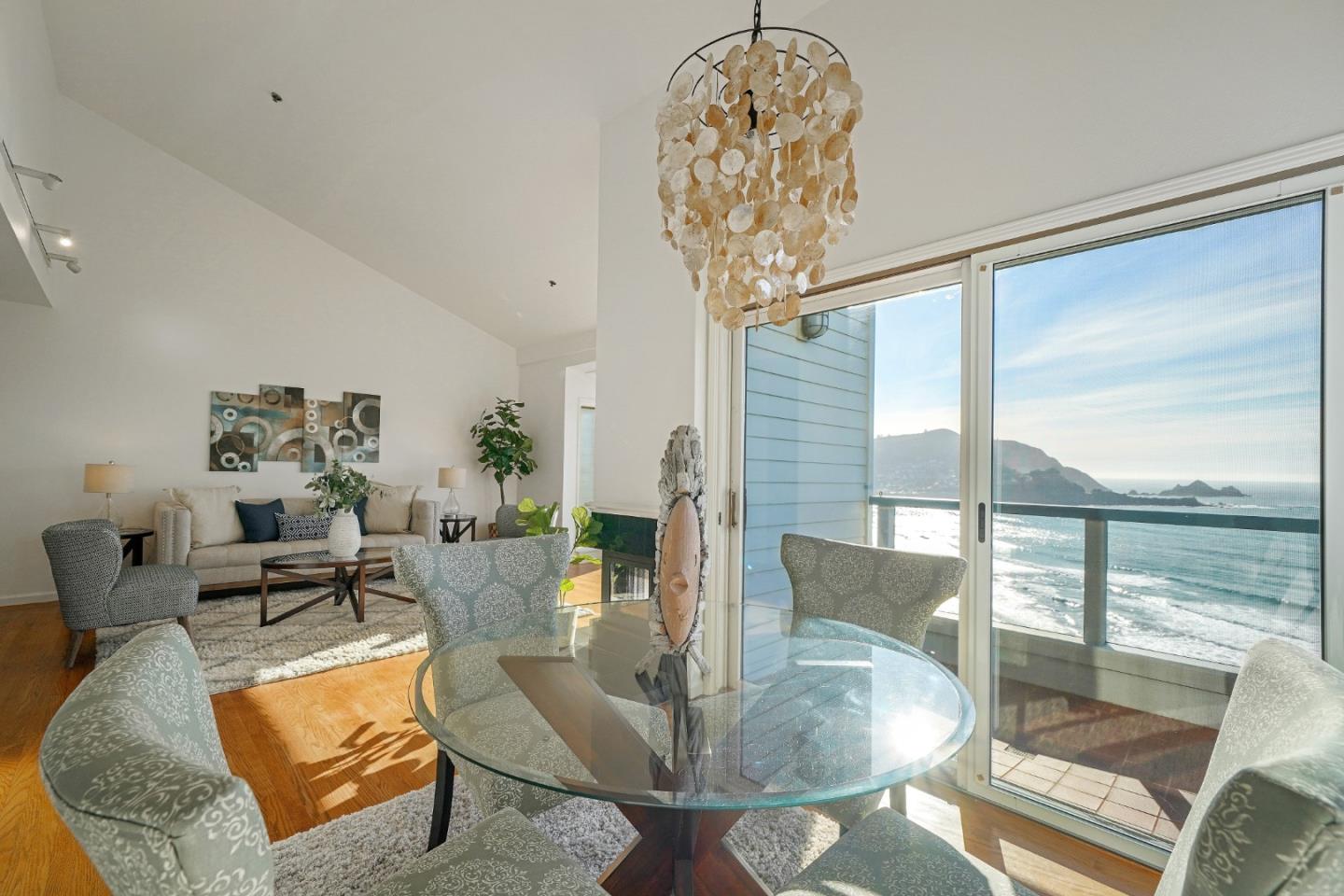 215 Roberts Road Pacifica, CA 94044 - Photo 9 of 40 a living room with dining table a chandelier and a large window