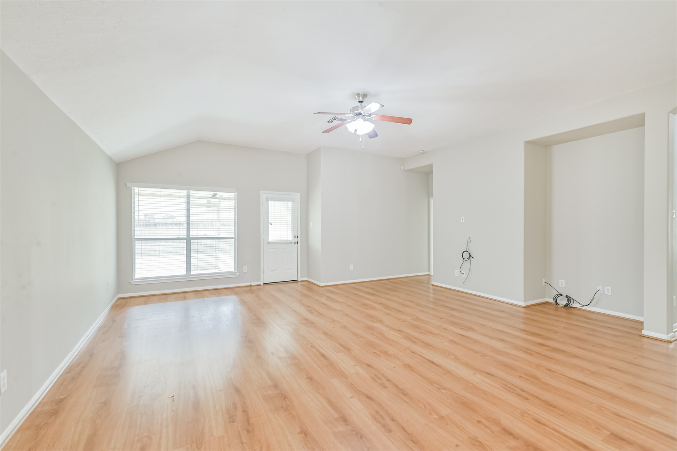 8331 Loetsch Ridge Way Spring, TX 77379 - Photo 10 of 31 High ceilings, abundant natural light, a ceiling fan, and beautiful laminate flooring enhance the bright and welcoming atmosphere.