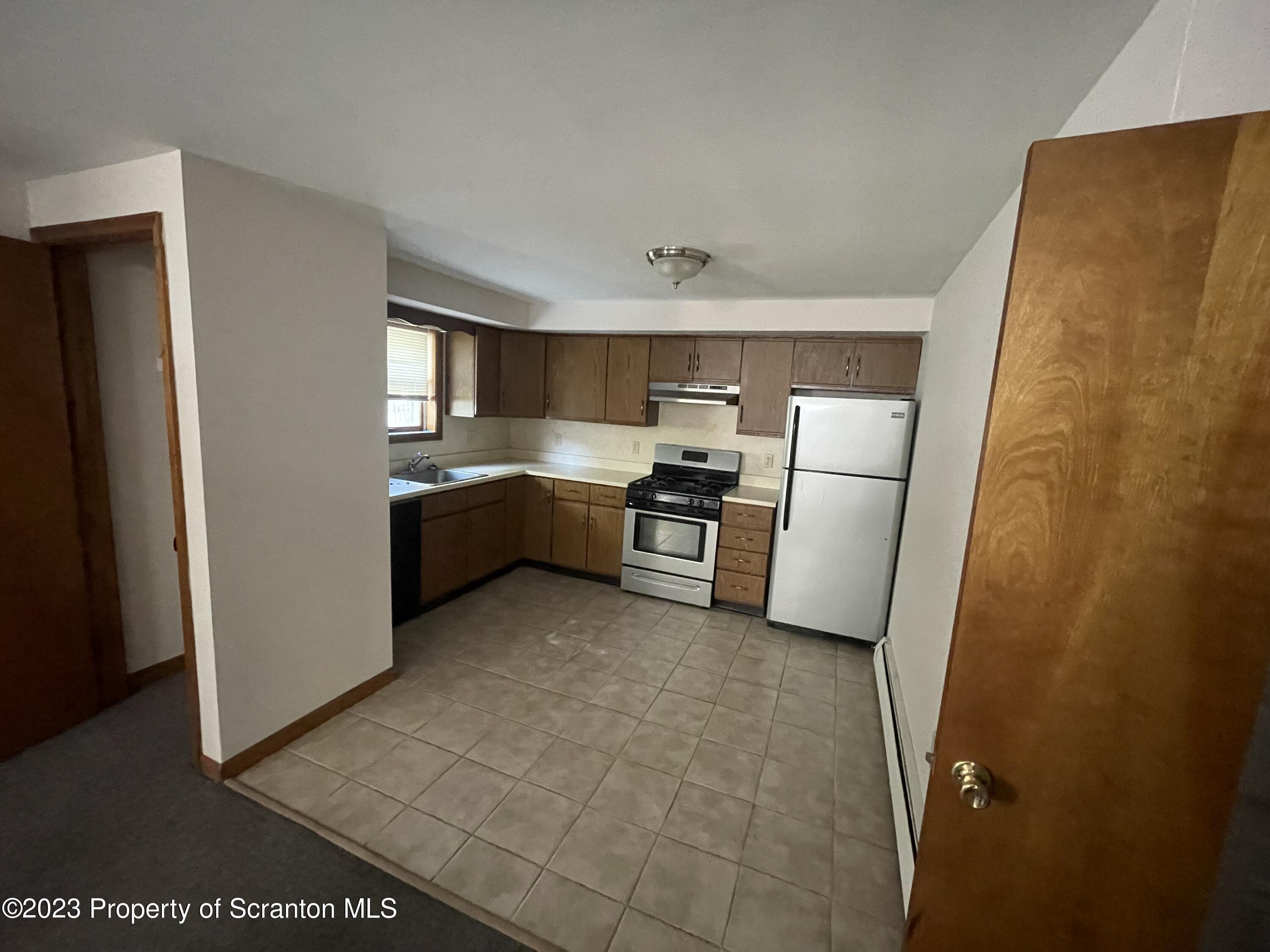 113 Frank Street, Unit 1 Dunmore, PA 18512 - Photo 2 of 9 a kitchen with stainless steel appliances granite countertop a refrigerator and a stove