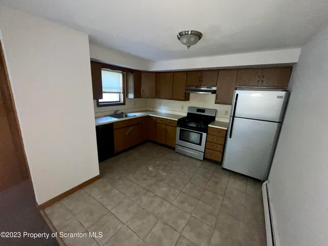 a kitchen with sink refrigerator and stove