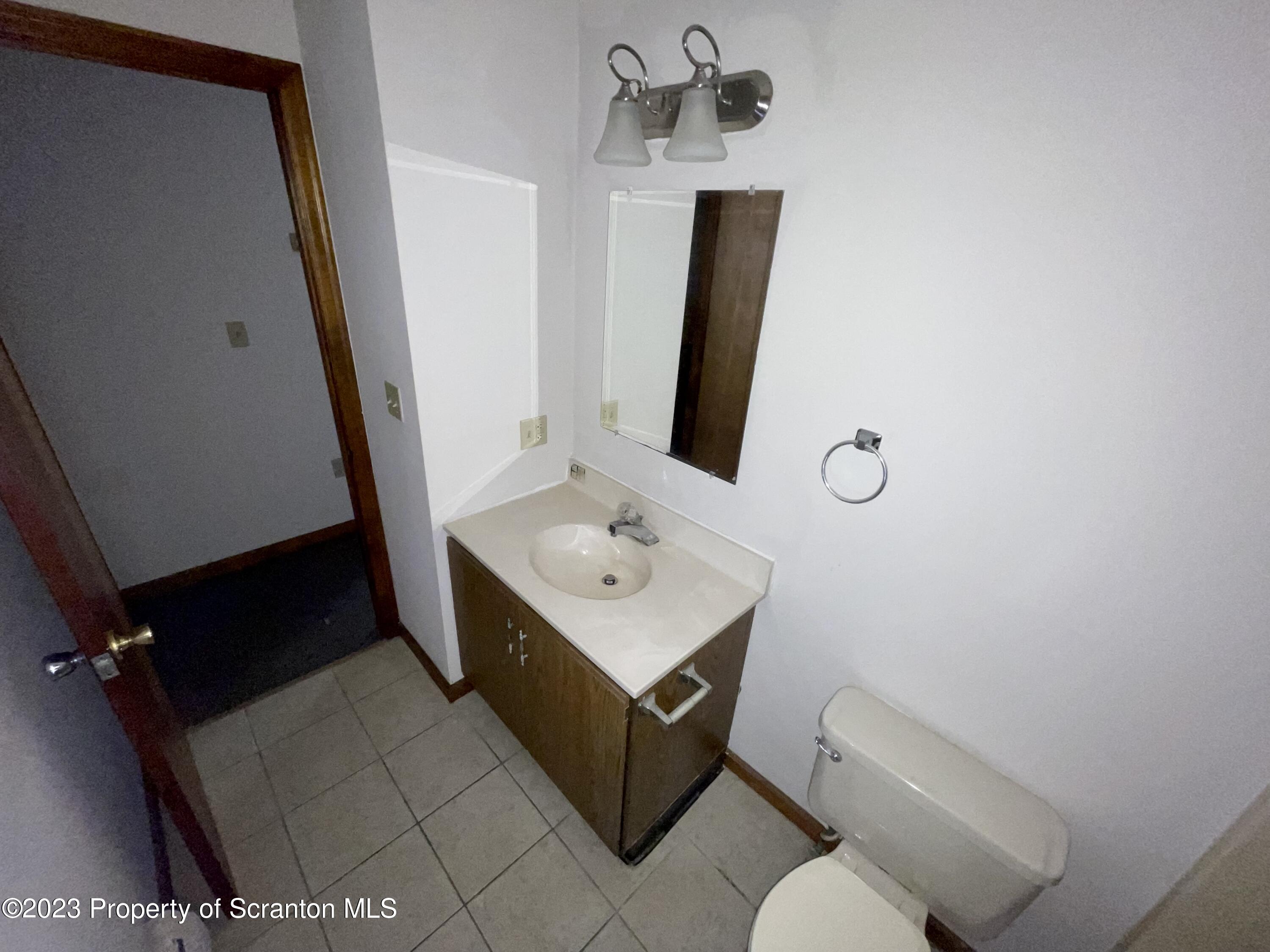 113 Frank Street, Unit 1 Dunmore, PA 18512 - Photo 8 of 9 a bathroom with a sink toilet and mirror