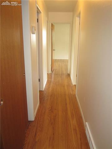 823 Cresta Road Colorado Springs, CO 80905 - Photo 15 of 36 Long hallway from Entryway/Foyer leading to Main Level 3 Bedrooms and 2 Baths. Also features a large linen closet (MORE STORAGE) and original hardwood floors.