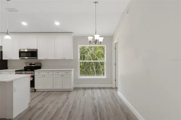 a kitchen with stove cabinets and wooden floor