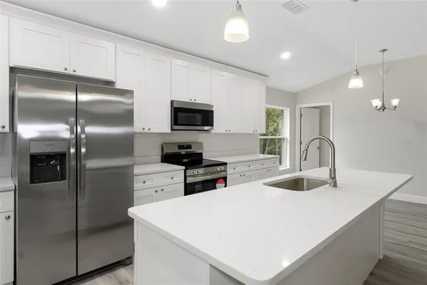 a kitchen with white cabinets and stainless steel appliances