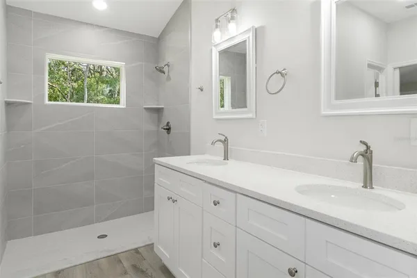 a bathroom with a sink a window and a shower