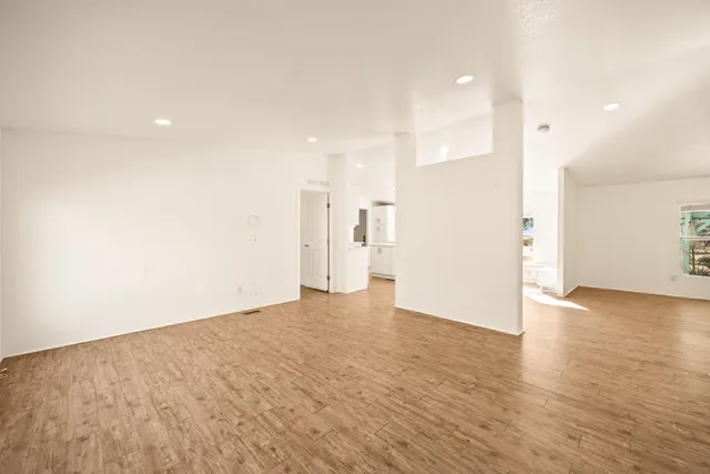 a view of an empty room with wooden floor