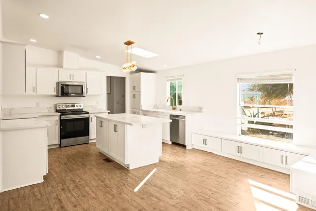 a kitchen with stove a sink and white appliances