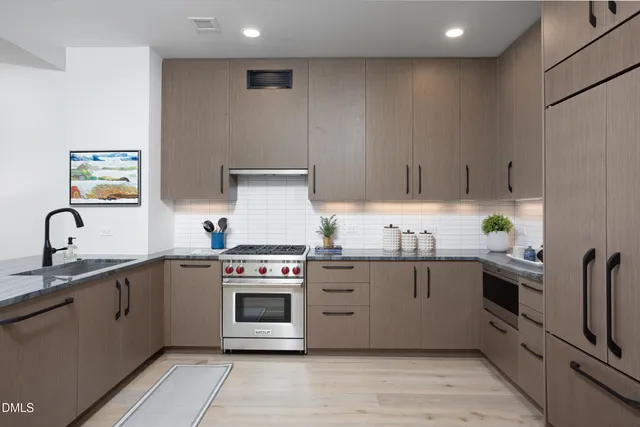 a kitchen with stainless steel appliances granite countertop a stove sink and cabinets