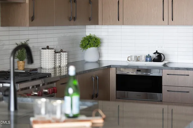 a kitchen with stainless steel appliances granite countertop a sink and a stove