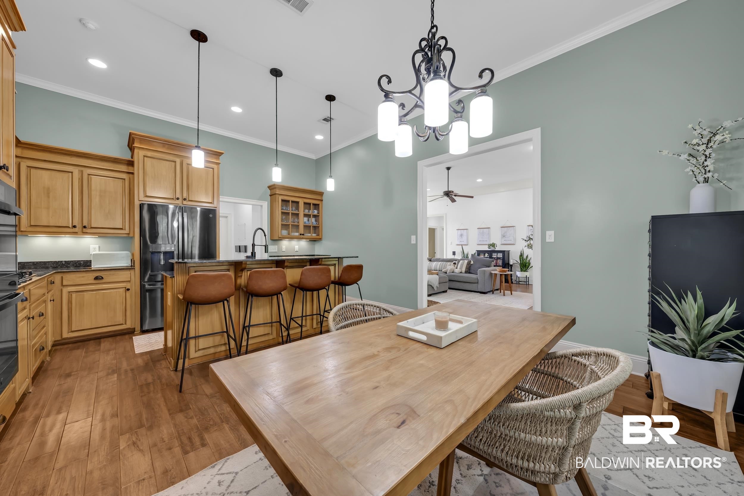 8137 Pine Run Daphne, AL 36527 - Photo 21 of 67 Dining area with a wood-finish table, distinct chandelier, and an open doorway to a living space
