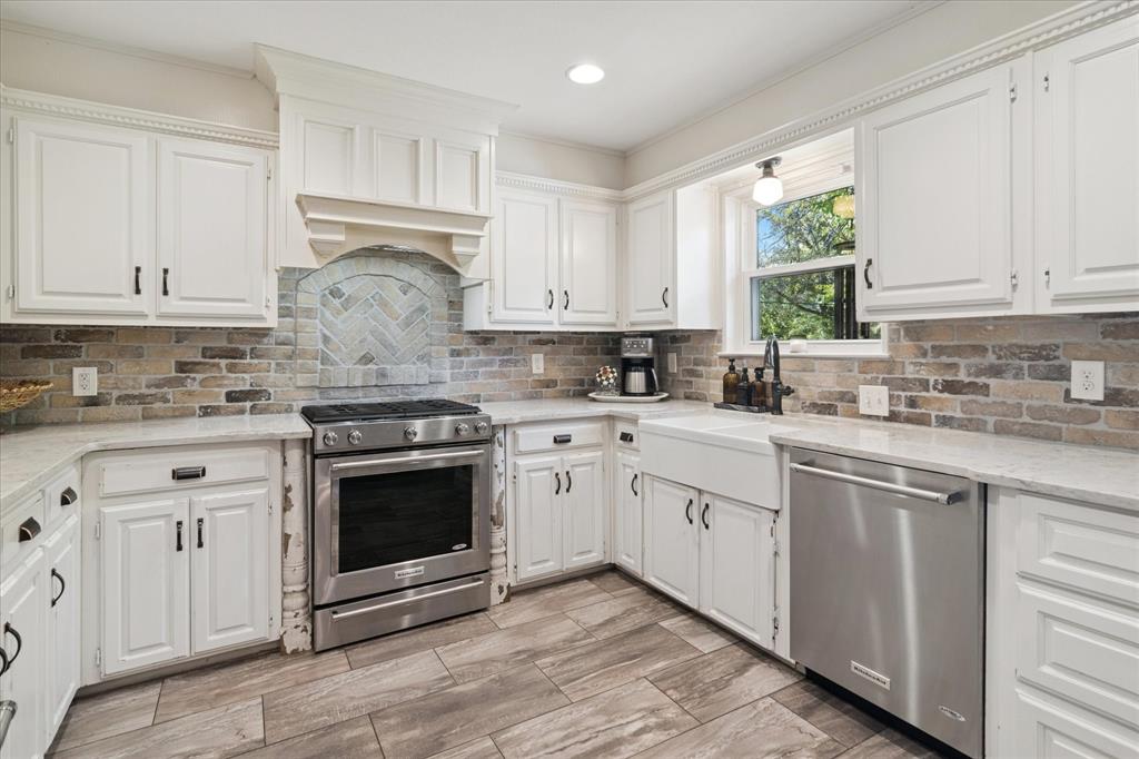 312 Old Justin Road Argyle, TX 76226 - Photo 11 of 24 a kitchen with stainless steel appliances granite countertop a stove a sink and white cabinets
